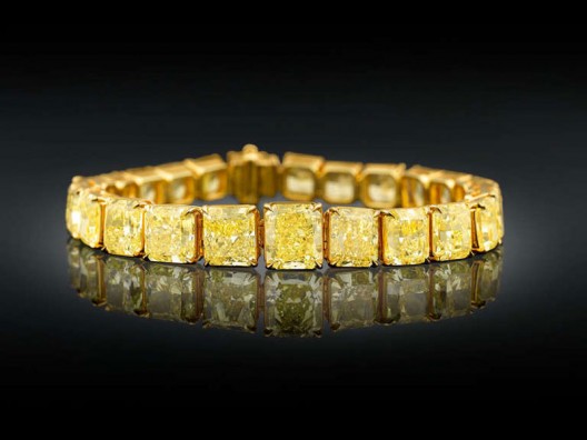 Twenty-five of the most beautiful, perfectly matched Natural Fancy Vivid yellow diamonds, totaling 55.66 carats, create a breathtaking golden glow in this incredible graduated bracelet