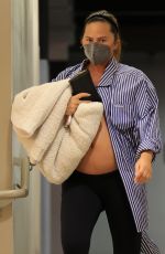 Chrissy Teigen shows off her huge baby bump ahead of a doctor
